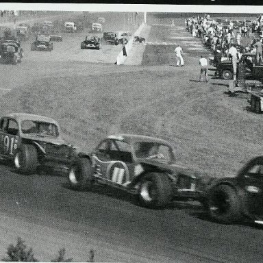 Donnie Allison leads Ray Hendrick while Freddy Fryar flips the 04 sedan in the background