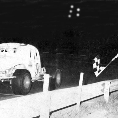 Chuckie Boos takes checkered flag from Flagman on old platform 1967