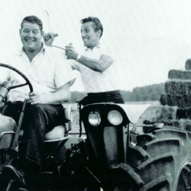Tiger Tom and Tiny Lund on Tractor Hauling Hay.