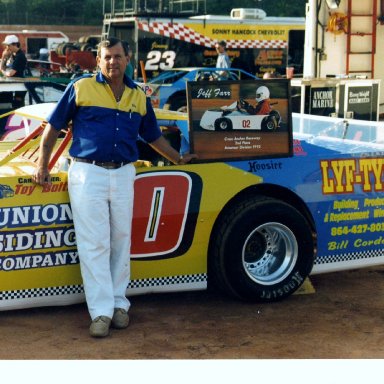 BILLY SCOTT DISPLAYS RACING PHOTO OF GRANDSON 1990S'