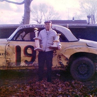 Dick Holmberg holding a couple of the trophies won by his driver Rene Charland FGURE 8S