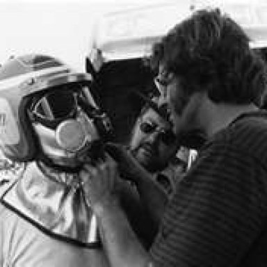 Al Hanna helped Shirl Greer into his firesuit. www.nhra.com.