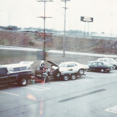 Tk & Ruth  working on ss-ha 69 Camaro in parking lot 1977 Indy